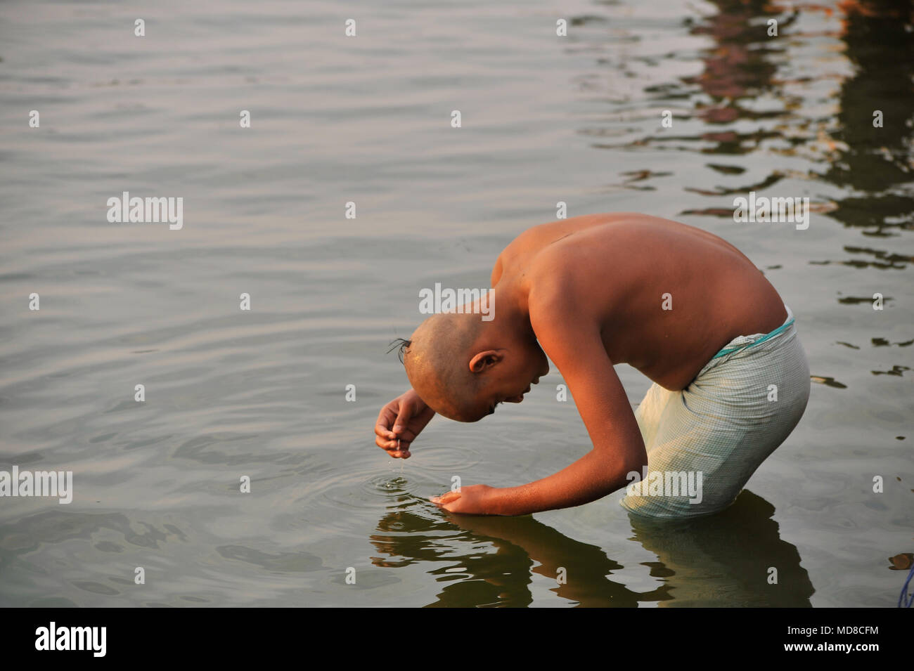 A boy with a sikha haircut takes a ritual wash in the Ganges (2/2) Stock Photo