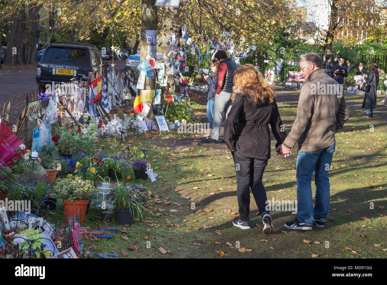 Visitors at an impromptu shrine or memorial to the pop star George Michael opposite the deceased musician’s house in Highgate, north London in 2017 Stock Photo