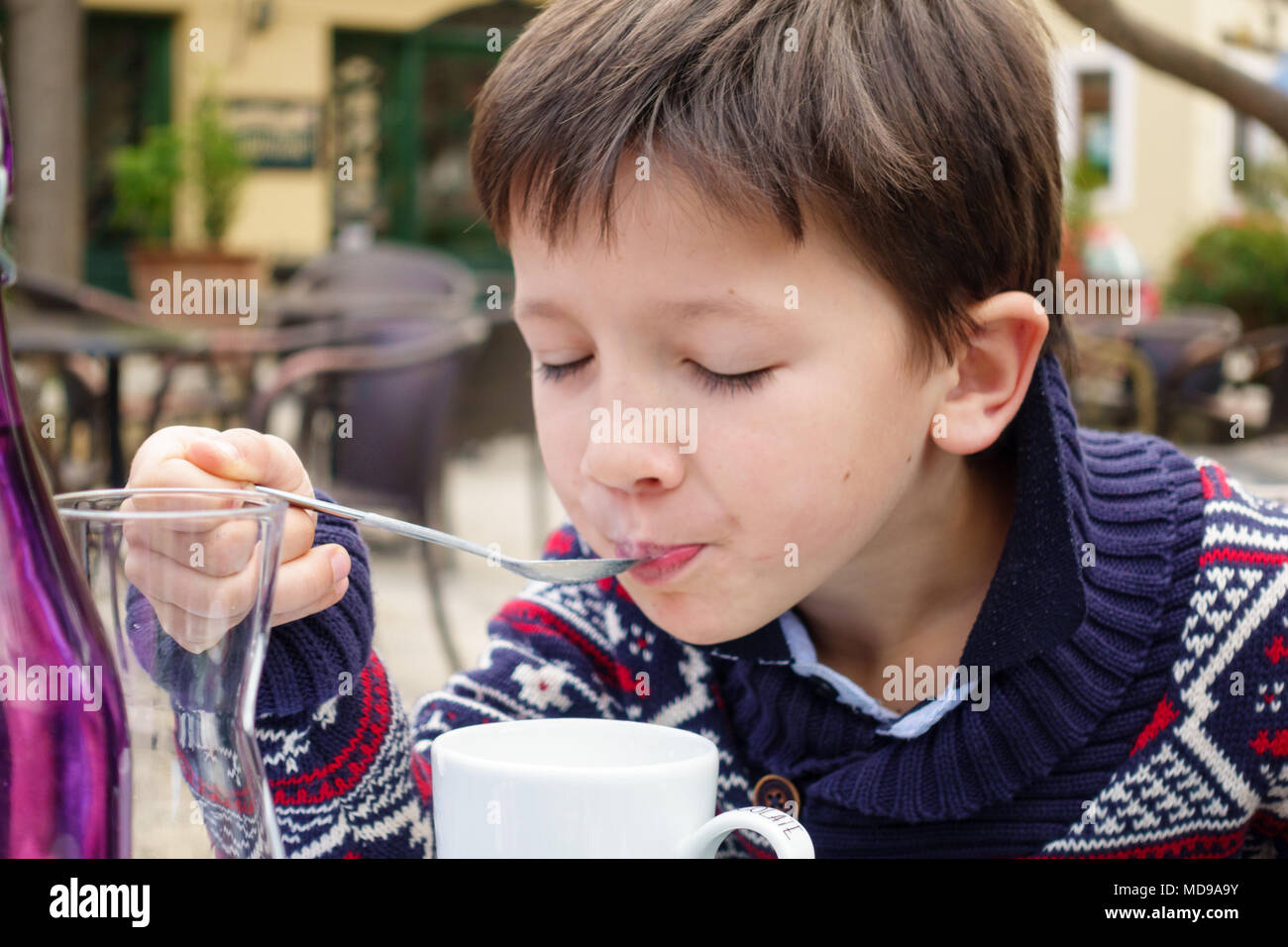 Boy sipping with closed eyes in a café, Greece Stock Photo