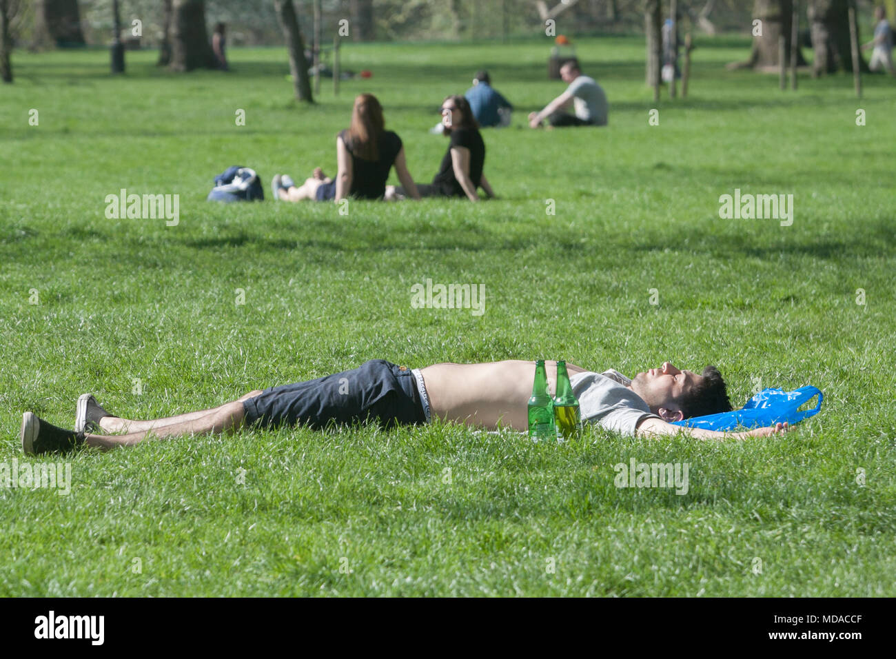 london-uk-19th-april-2018-uk-weather-a-man-sunbathes-in-green-park