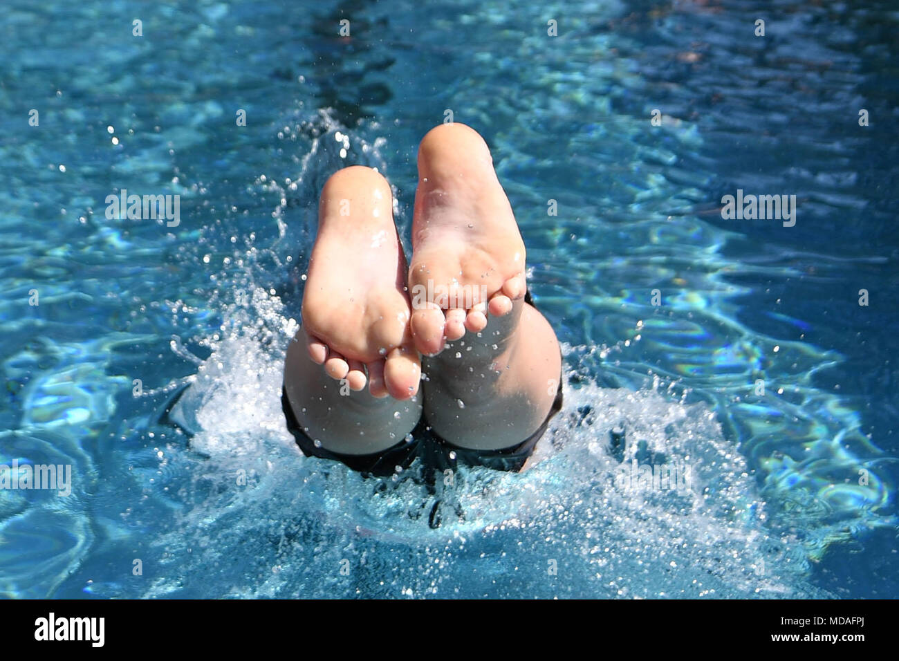 19 April 2018, Unna, Germany: A boy jumping a head start in the water of the Borne Camp pool. The pool opened its first day of the season, a day ago. Photo: Bernd Thissen/dpa Stock Photo