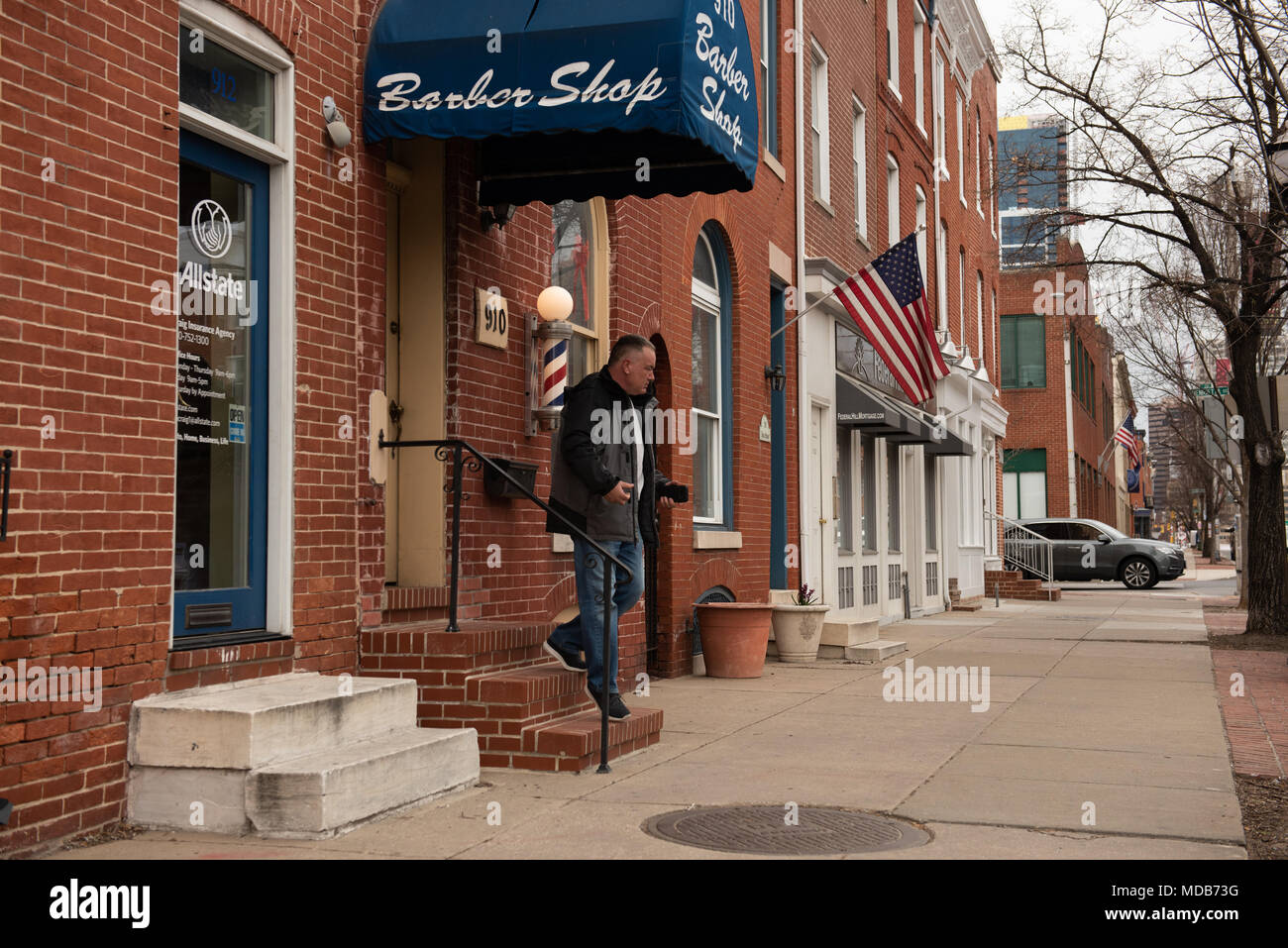 Baltimore, Maryland, USA. Man departs old-fashioned barber shop in historic Federal Hill District. Stock Photo
