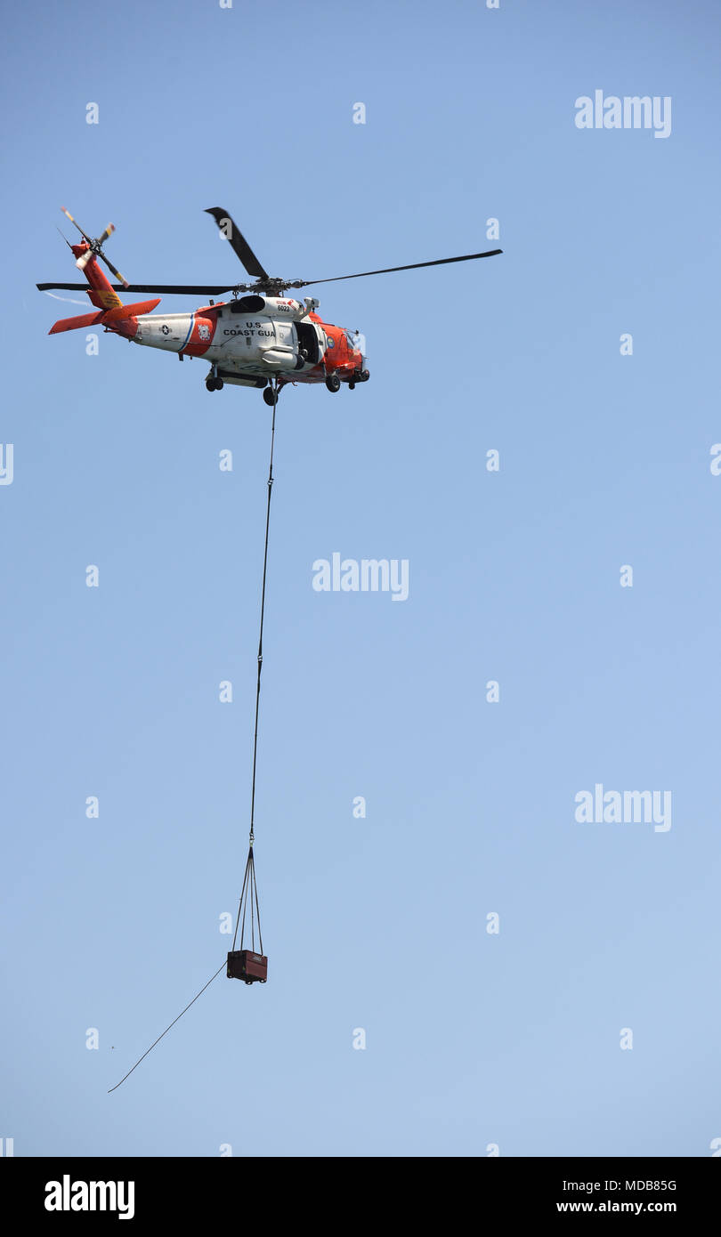 A Coast Guard HH-60 helicopter crew from Coast Guard Air Station San Deigo transported parts of a new navigational aid to the Anaheim Bay East Jetty Light 6, at Naval Weapons Station Seal Beach, Calif., April 18, 2018. The HH-60 helicopter crew transported 3 different parts where members of Coast Guard Aids to Navigation Team Los Angeles-Long Beach, assembled the new navigational aid. U.S. Coast Guard photo released by Petty Officer 3rd Class DaVonte' Marrow. Stock Photo