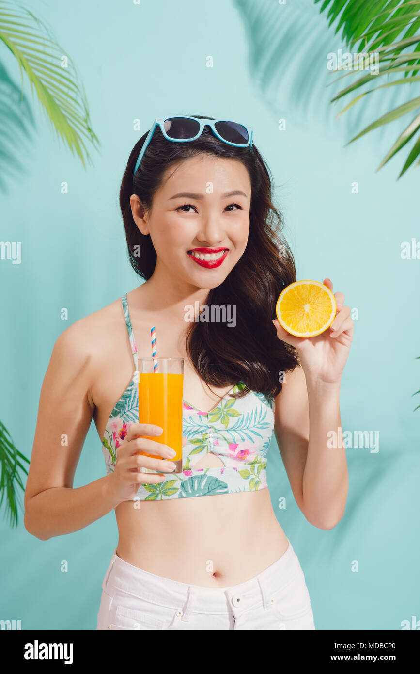 Fashion pretty asian woman with juice cup over colorful blue background  Stock Photo - Alamy