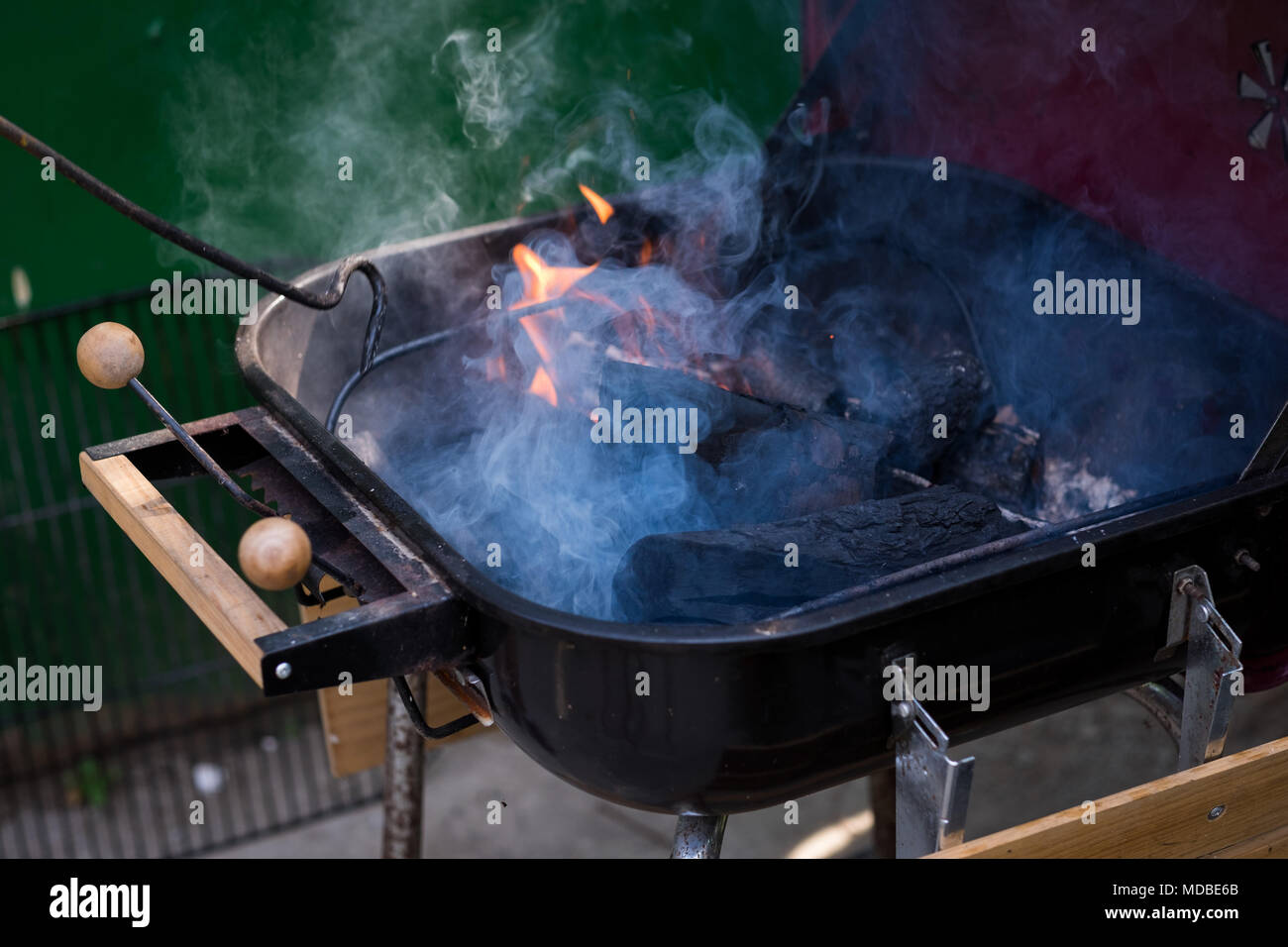 Turning charcoals on fire in a barbecue outside Stock Photo