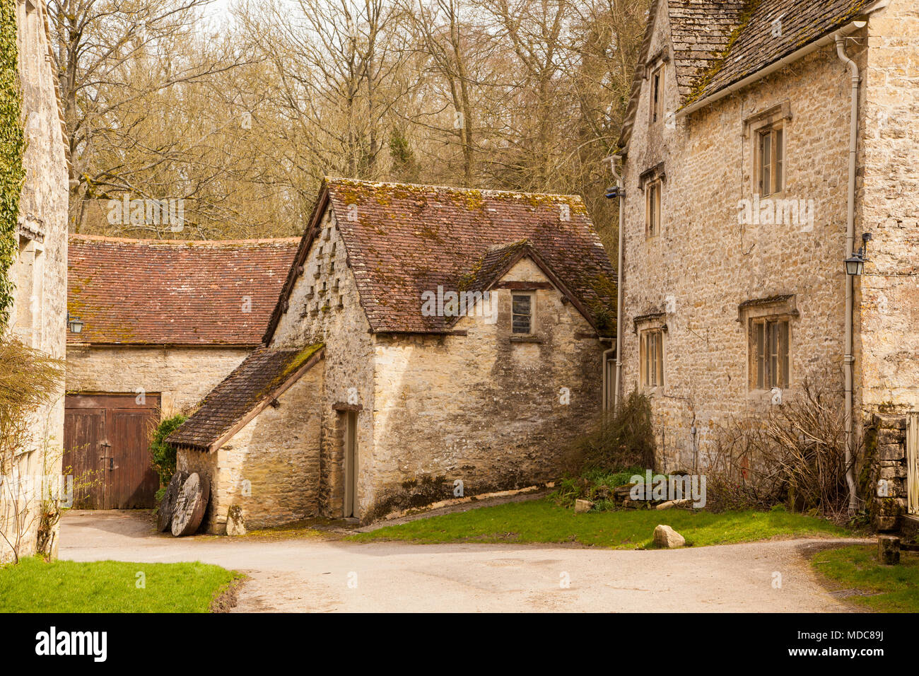 Traditional Cotswold's stone farmhouse with country lane winding