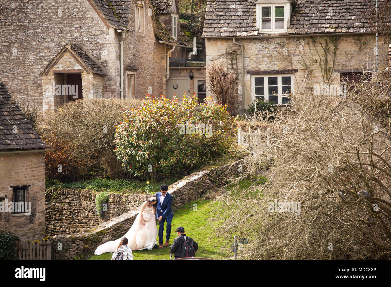 Asian bride and groom pose for wedding photographs in the  English Cotswold village of Bibury Gloucestershire Stock Photo