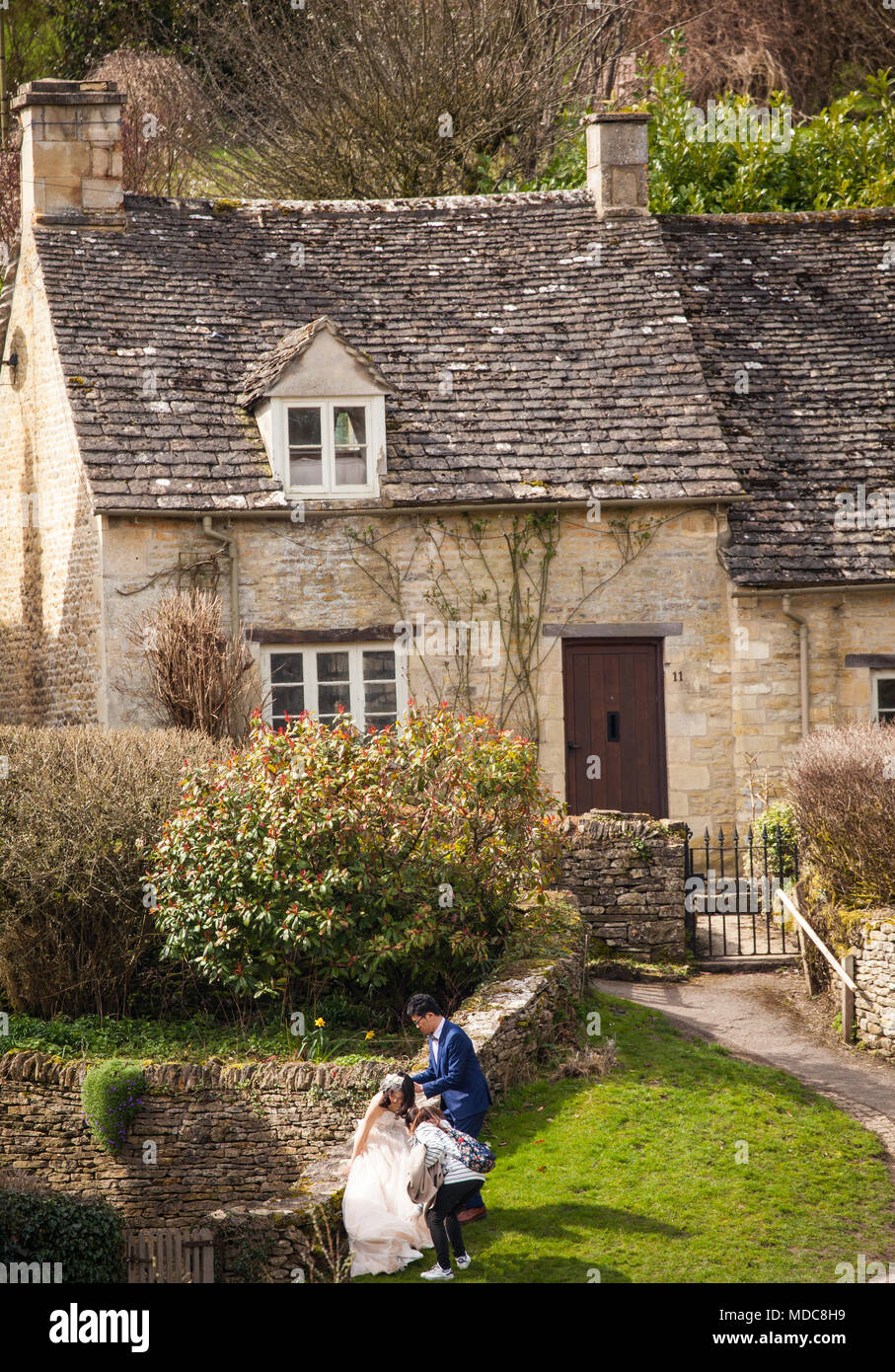 Asian bride and groom  pose for wedding photographs in the  English Cotswold village of Bibury Gloucestershire Stock Photo