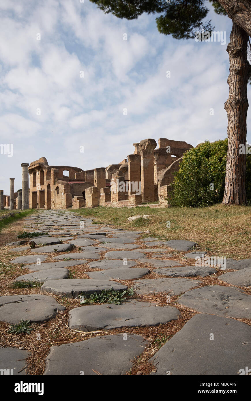 Roman road with the ruins of Ostia Antica in the background. Stock Photo