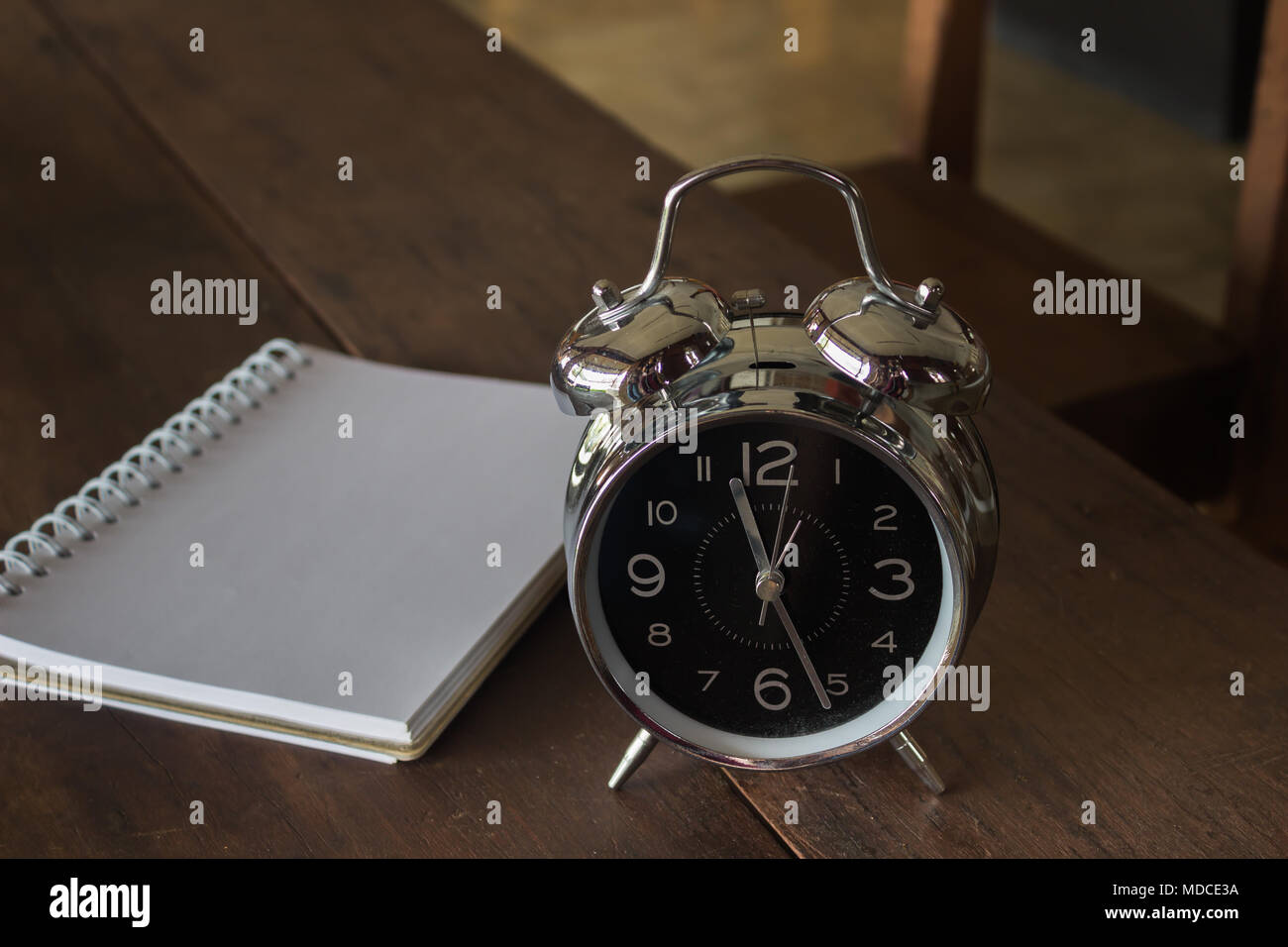 Retro alarm clock with blank realistic spiral notepad notebook on