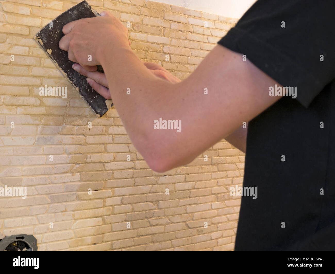 applying mosaic tiles on wall Stock Photo