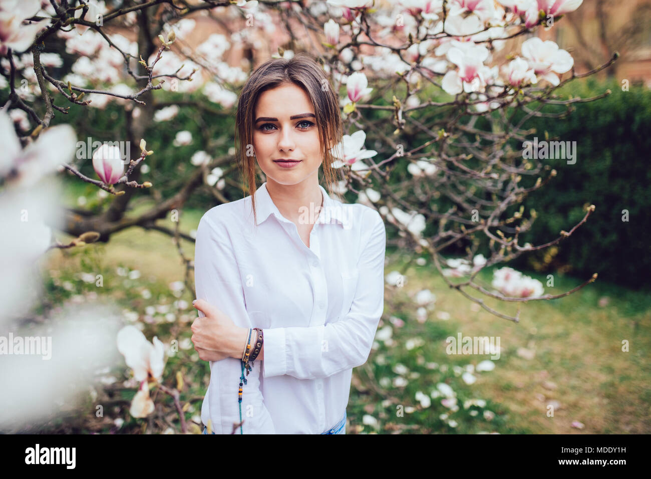 beautiful young woman near the blossoming spring tree Stock Photo - Alamy