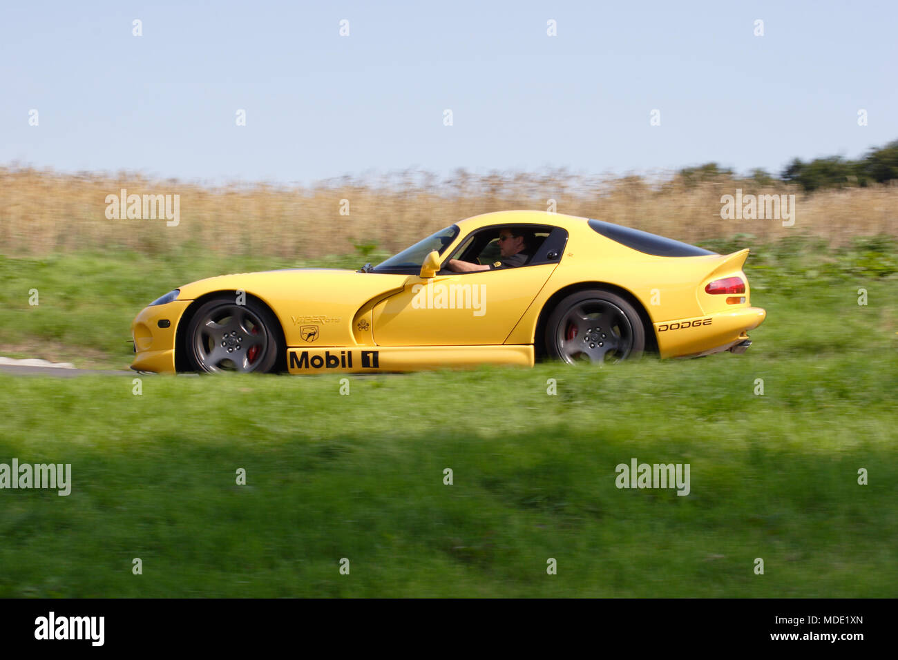 Profile (side view) of yellow Dodge Viper GTS American sports car driving fast. Stock Photo