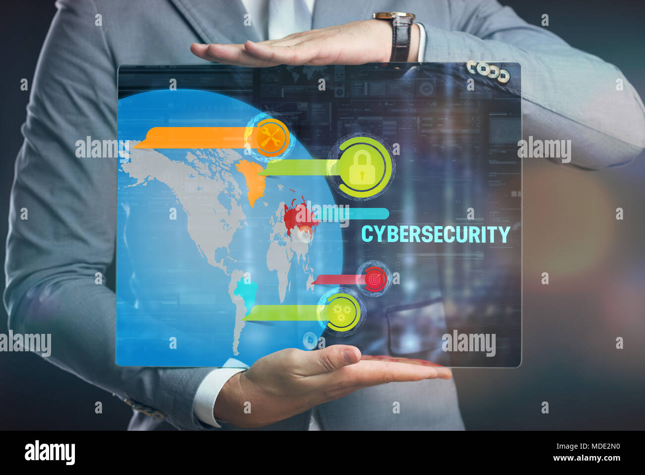 Business, technology, internet and networking concept. Young businessman working on his laptop, select the icon security on the virtual display. Stock Photo