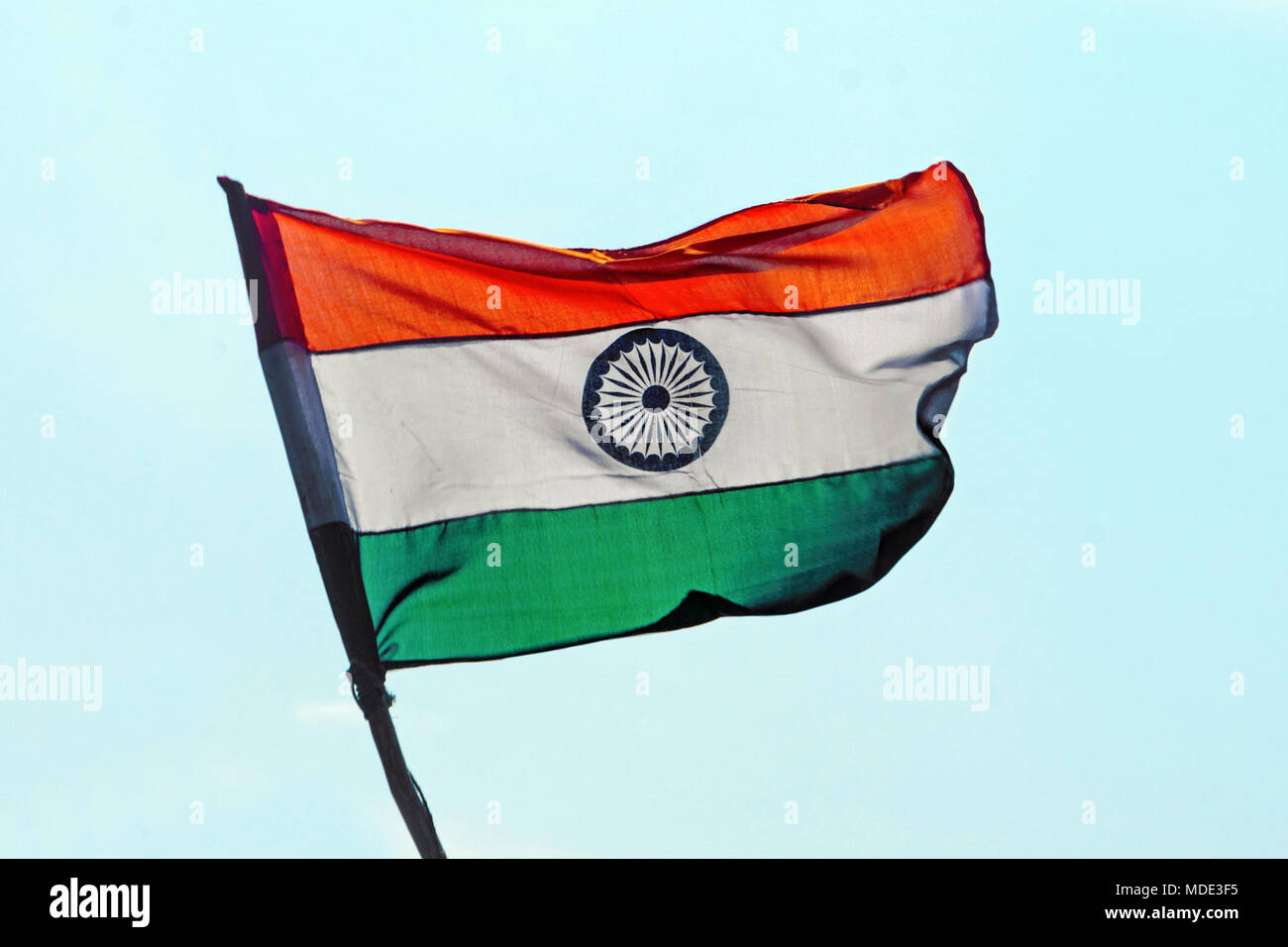 Flag of India on the mast. Indian flag develops against the background of  the blue cloudless sky Stock Photo - Alamy