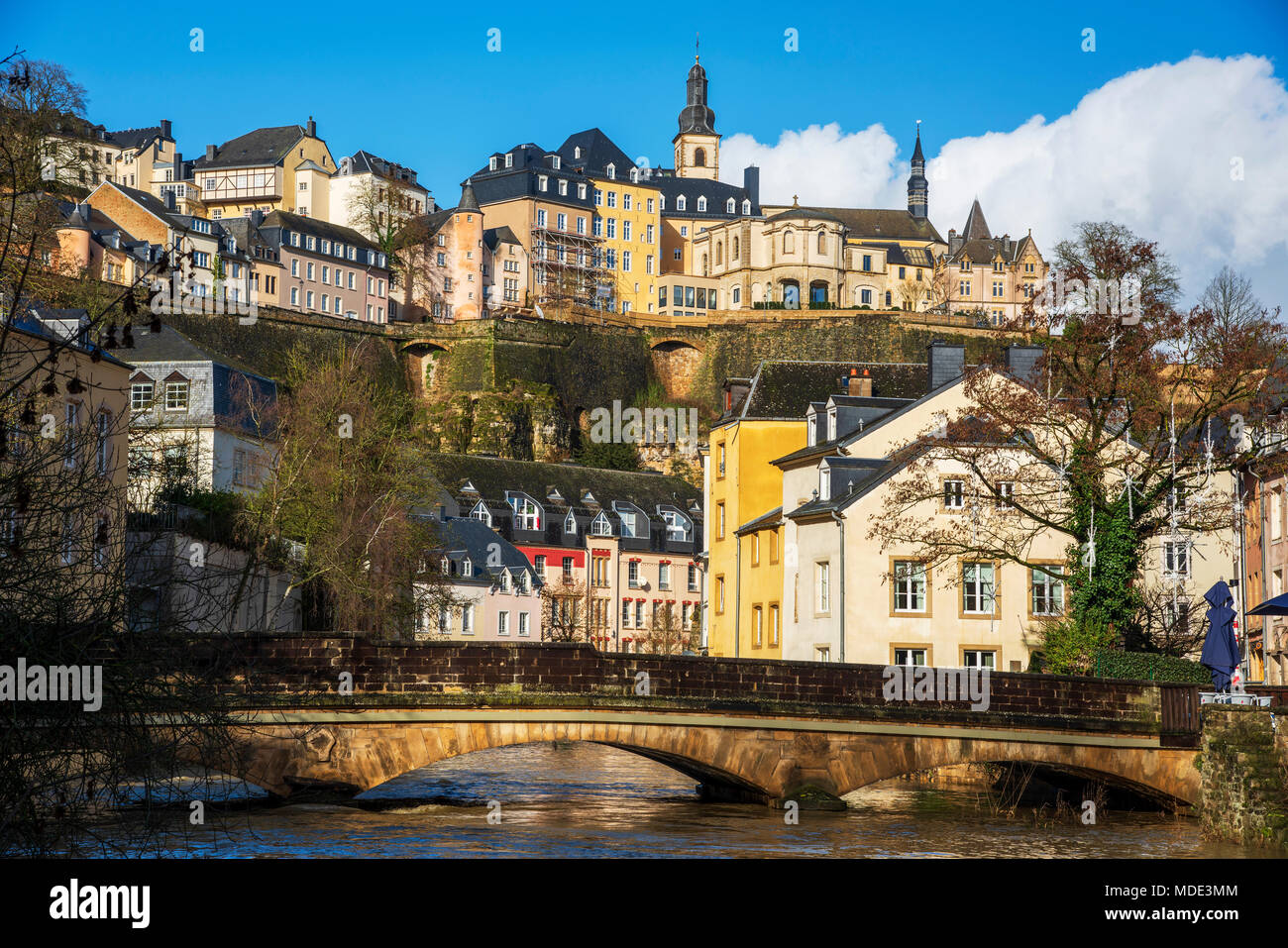 a view of the Alzette River as it passes through the Grund Quarter in Luxembourg City, Luxembourg, and the Ville Haute Quarter on the top left, highli Stock Photo