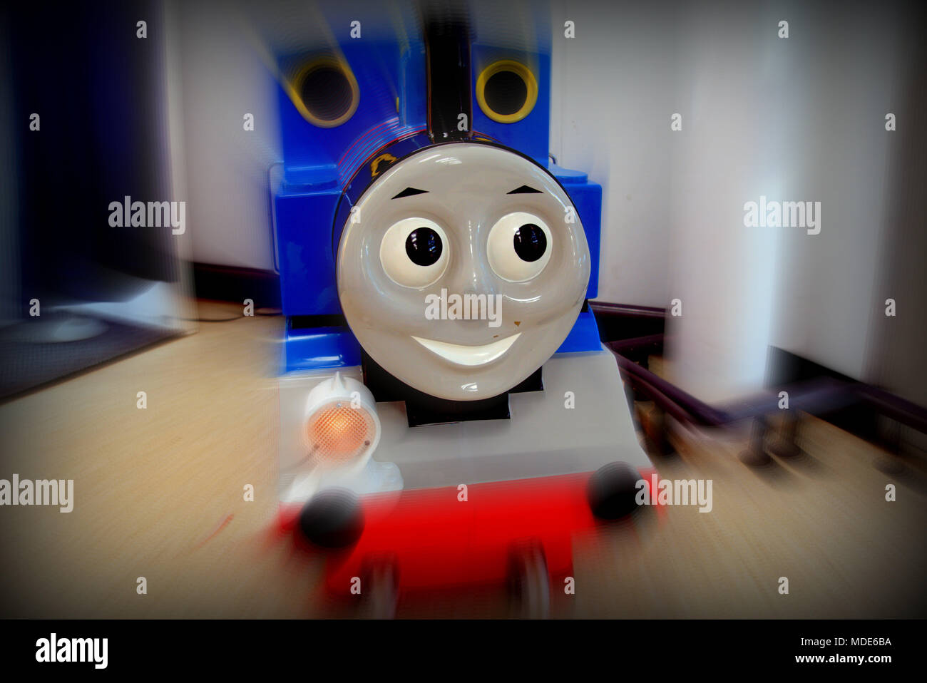 Thomas the tank engine cartoon character as a children's ride with motion blur close up toy  smiling happy face with nobody copy space Stock Photo