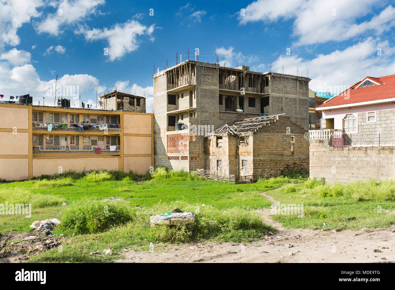 A ruin next to a building under construction, a typical view in the village of Tassia in east Nairobi, Kenya. Stock Photo