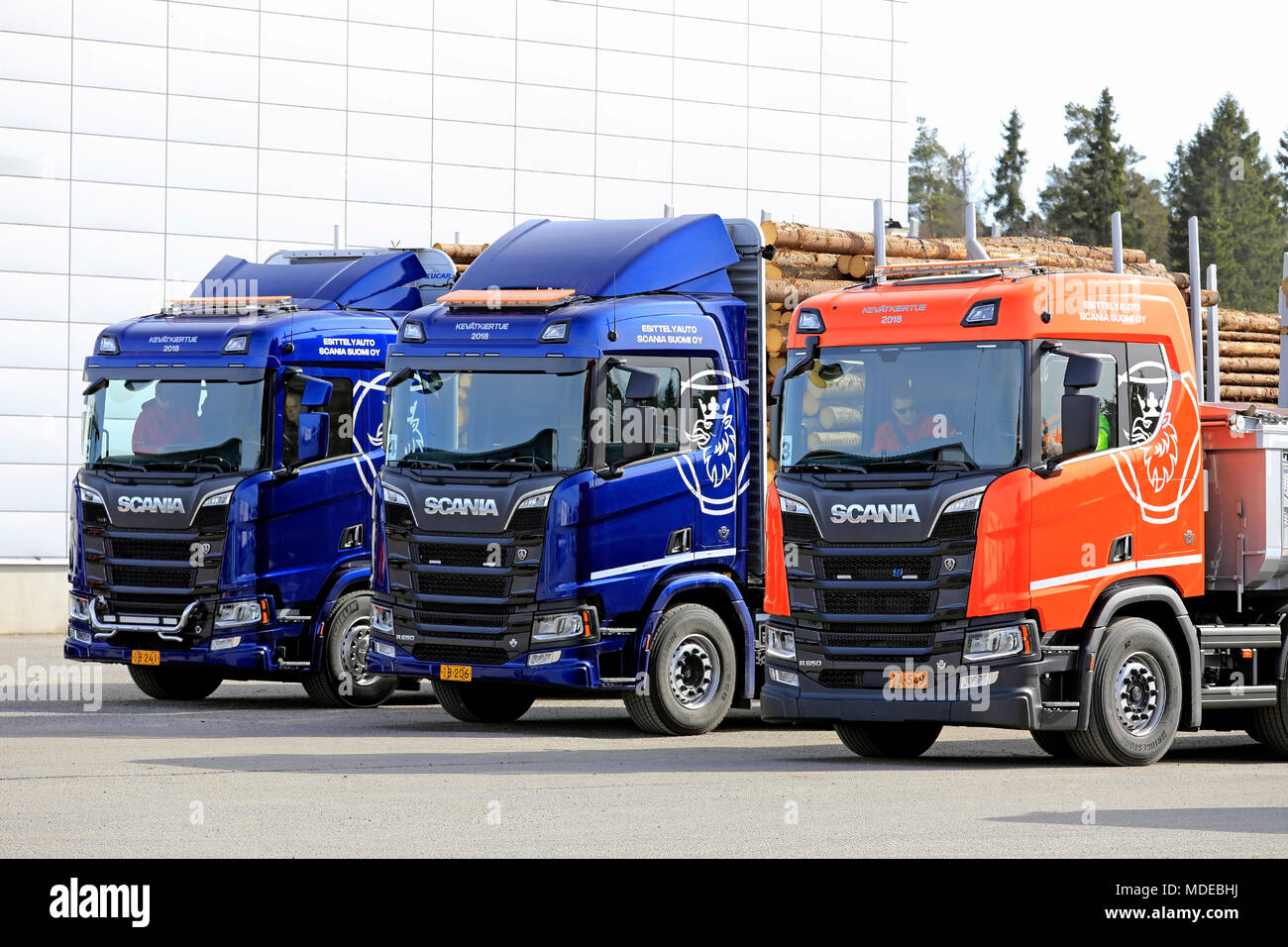 LIETO, FINLAND - APRIL 12, 2018: Three new Scania trucks, blue R730 and R650 for wood transport and orange R650 for construction during Scania Tour 20 Stock Photo