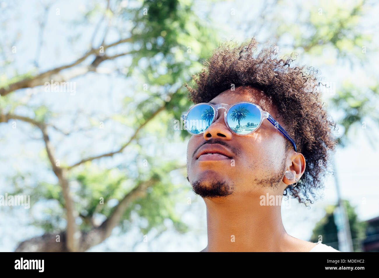 Man wearing sunglasses, looking up Stock Photo