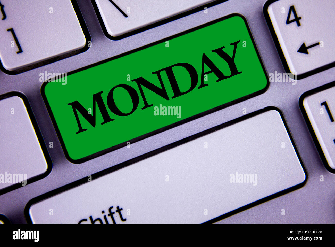 Word writing text Monday. Business concept for First day of the week Back to work Weekend is over Wakeup Early written Green Key Button White Keyboard Stock Photo