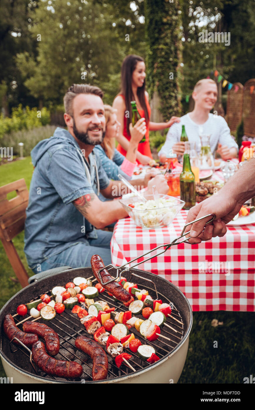 Young group of friends having a bbq party in the countryside Stock