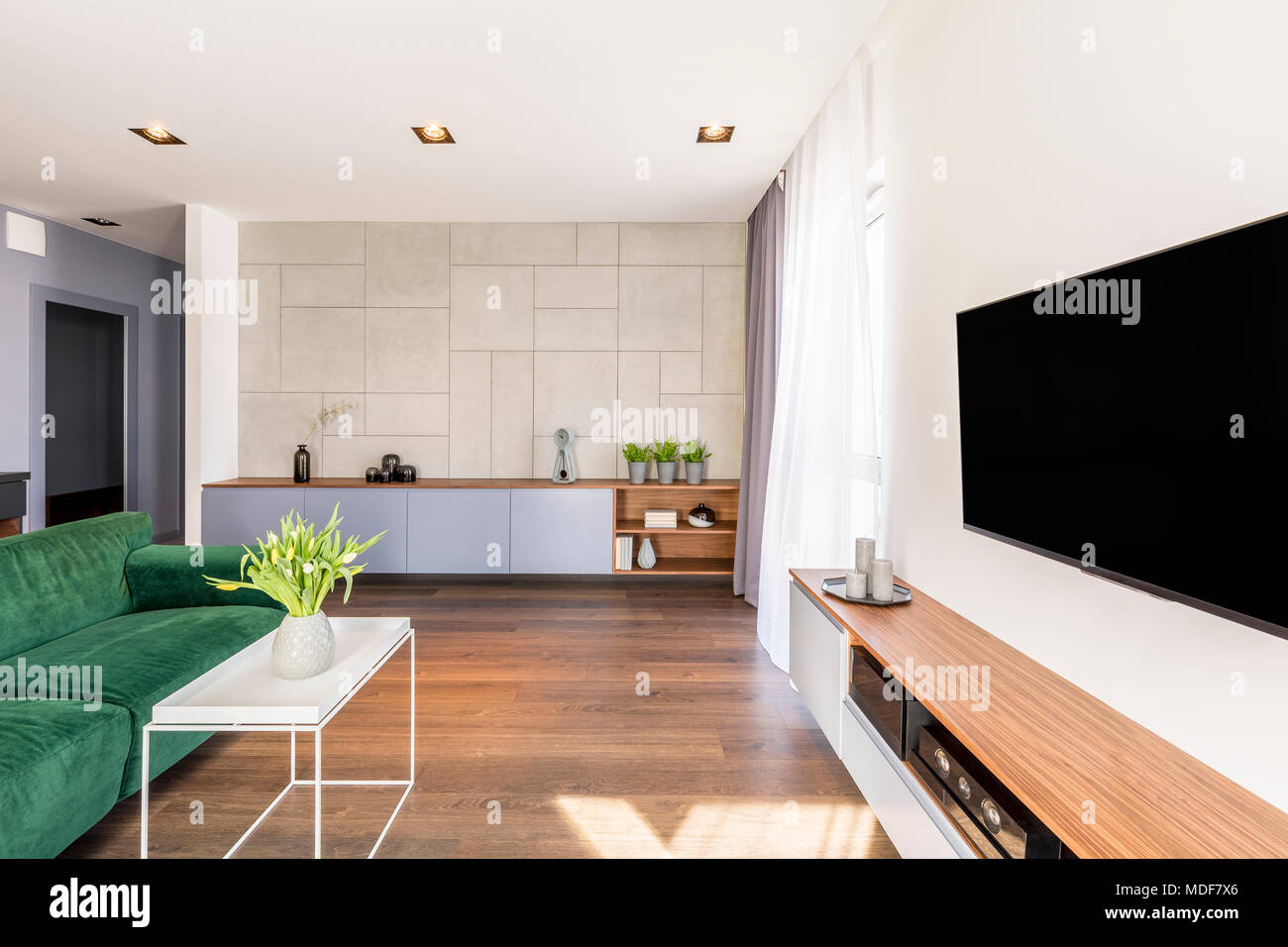 Large television in luxurious living room interior with yellow tulips