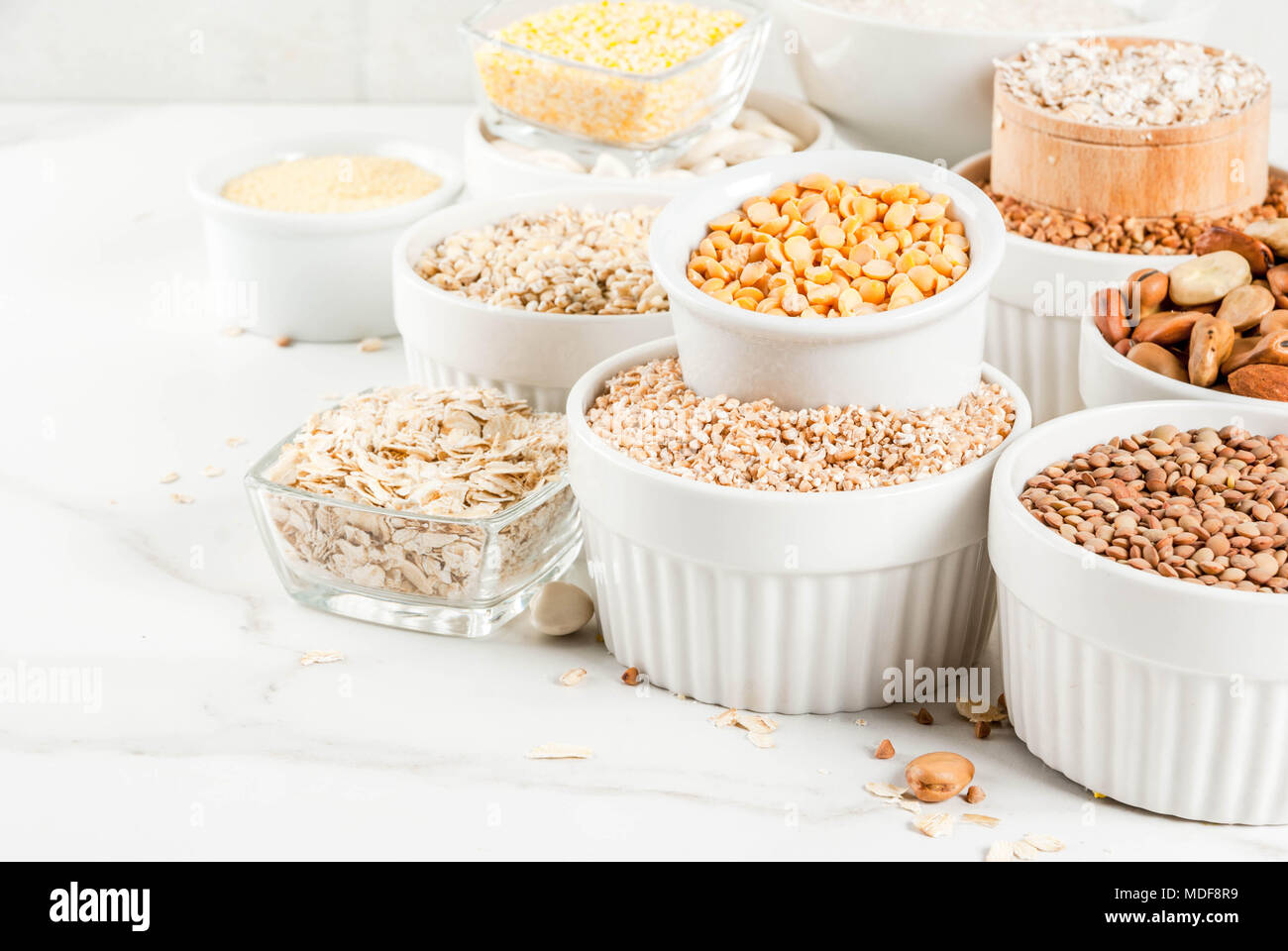 Selection various types cereal grains groats in different bowl on white