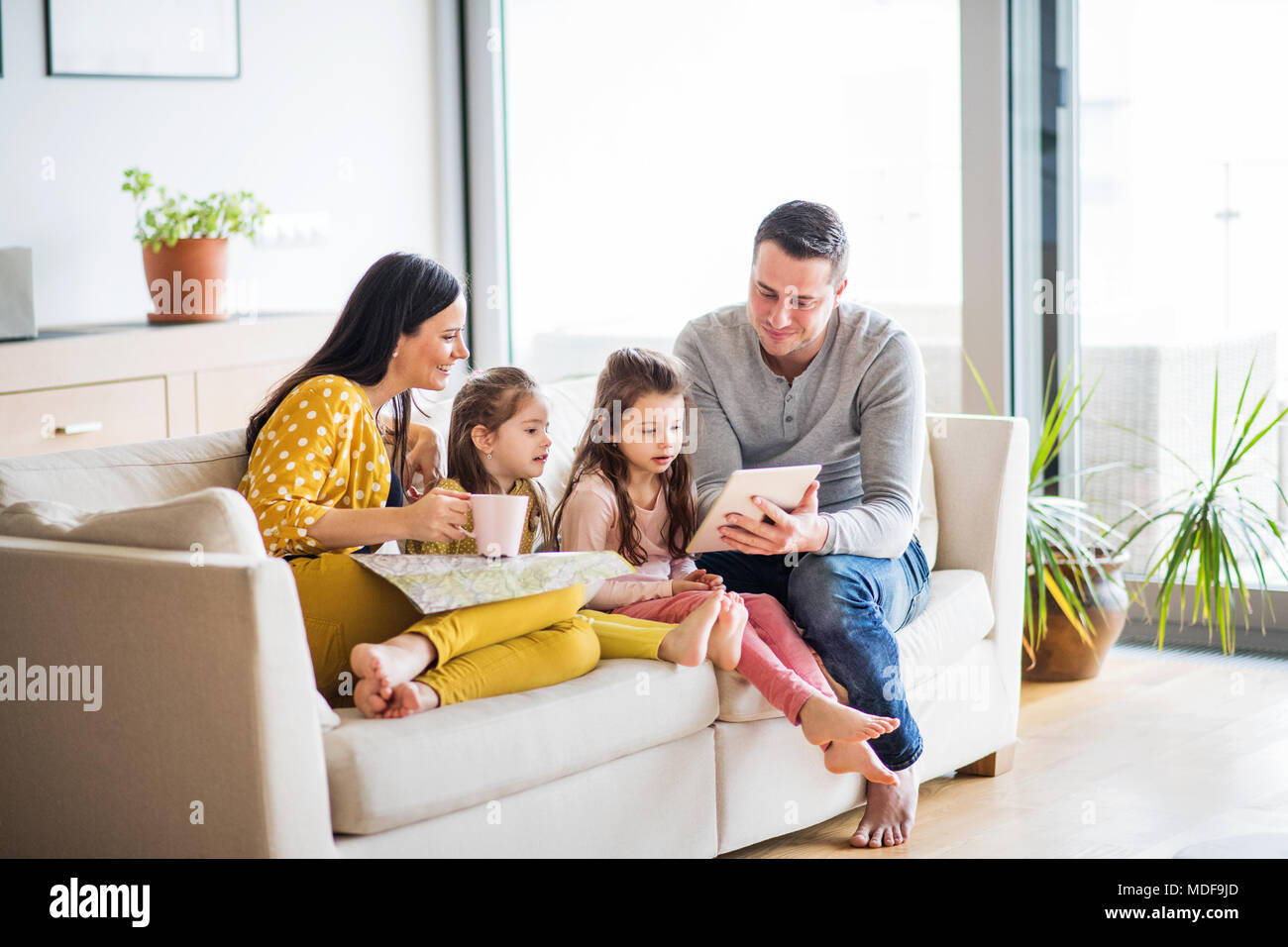 Young family with two children and tablet preparing for holidays Stock