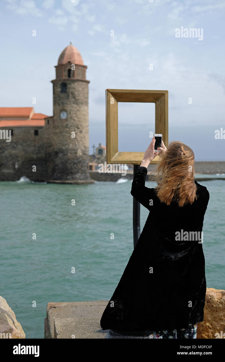 Tourists look through frames placed in the town of Collioure,France, by artist de Figueres. Stock Photo