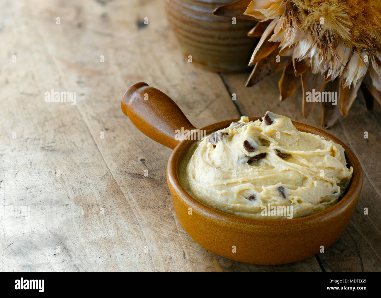 chocolate chip edible cookie dough , in a bowl, brown farm house color setting, selective focus on the subject  shot in window light , bokeh background​ Stock Photo