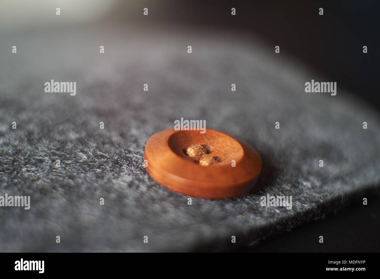 Sewn button playing with light, shadow, reflection and surfaces, selective focus. Stock Photo