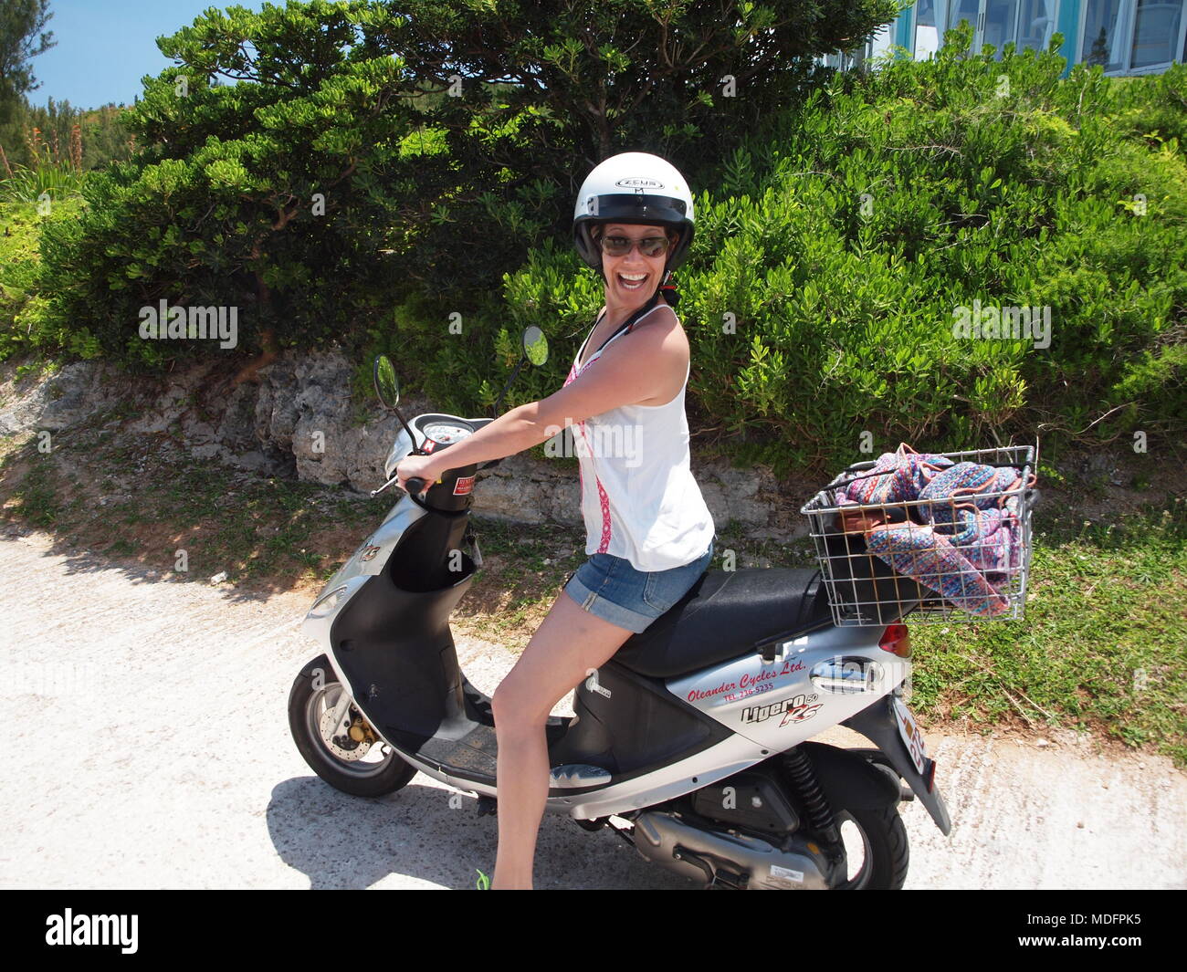 Smiling girl on scooter in Bermuda enjoying the spectacular climate and
