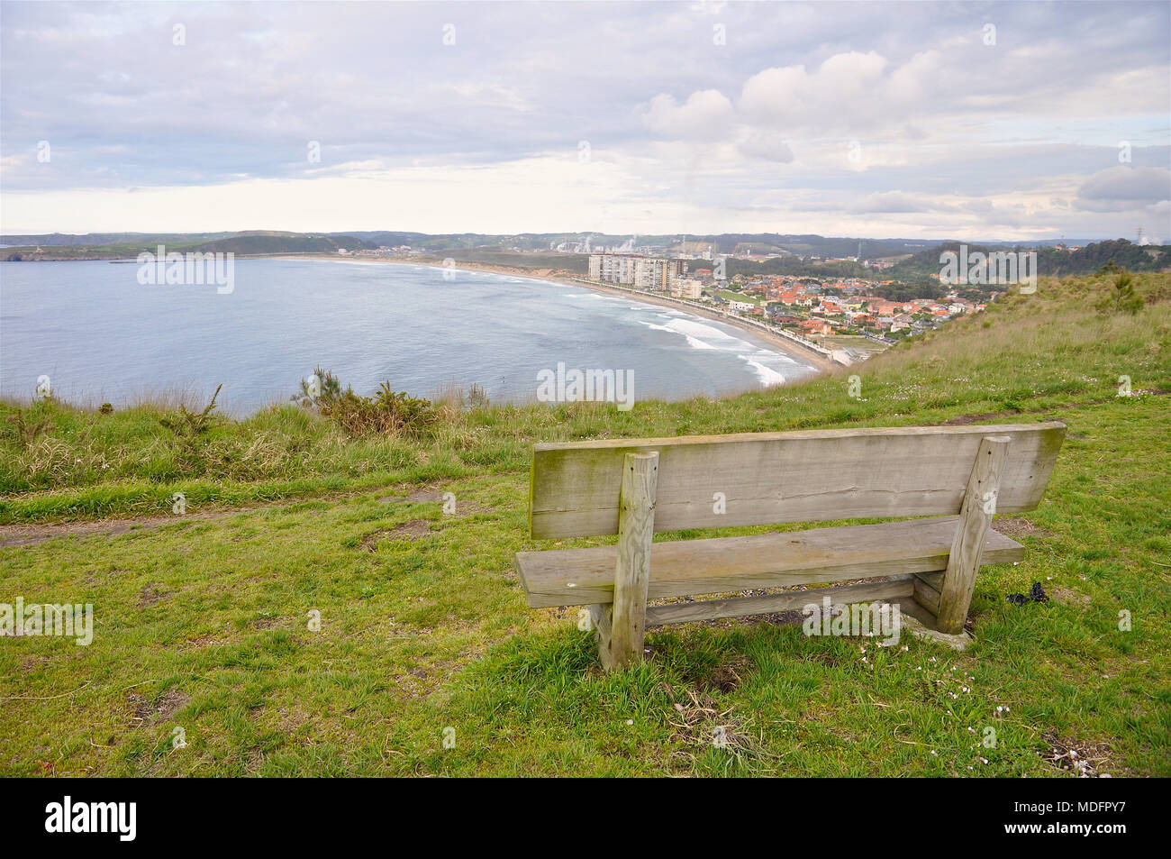 Bench by the sea with a privileged view of Salinas town and beach at Pinos Altos recreational area in Salinas (Castrillón, Asturias, Spain) Stock Photo