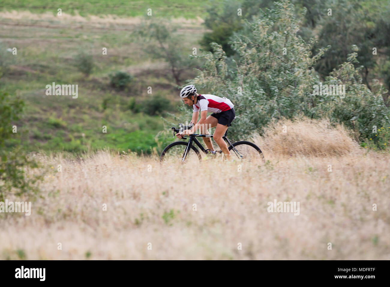 Professional cyclist training offroad riding in fields, bicycle rider