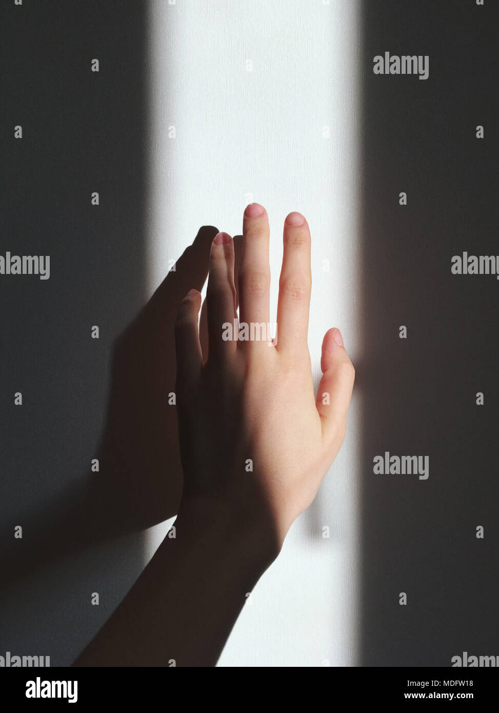 Woman's hand touching a wall Stock Photo