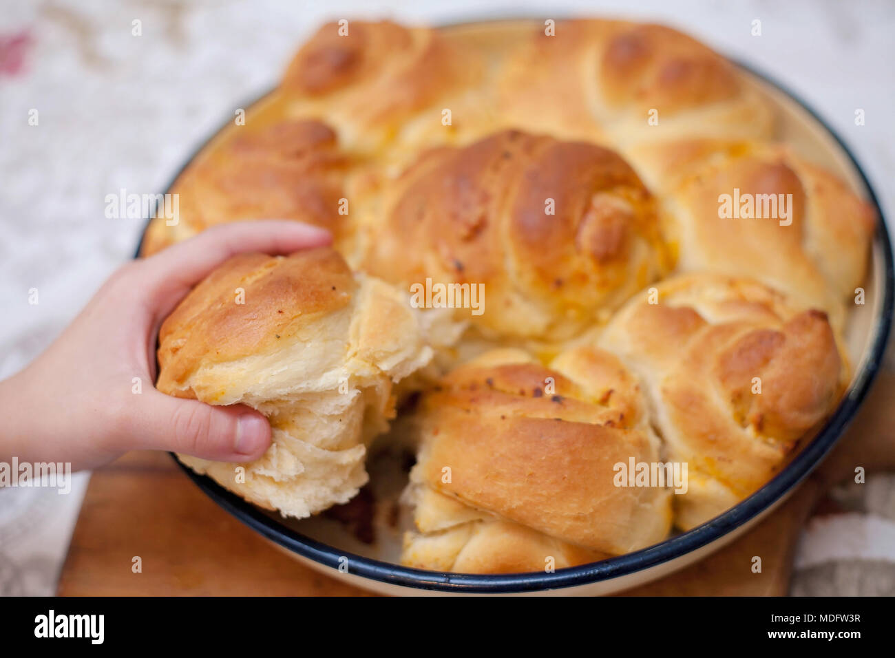 Boy's hand reaching for a piece of Bulgarian homemade bread Stock Photo