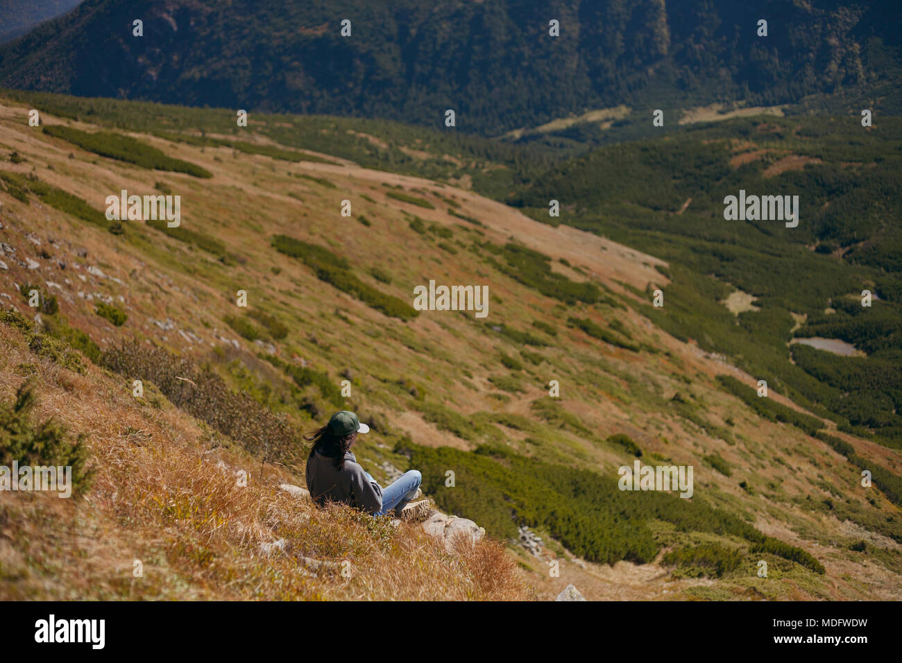 Woman sitting on a mountain slope, Ukraine Stock Photo