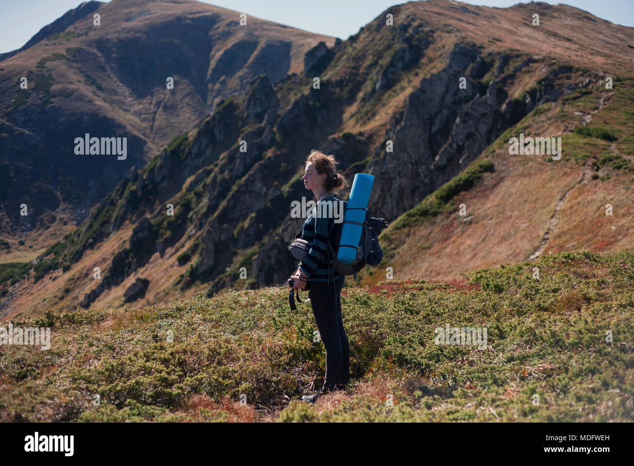 Woman standing on mountain slope looking at view, Ukraine Stock Photo