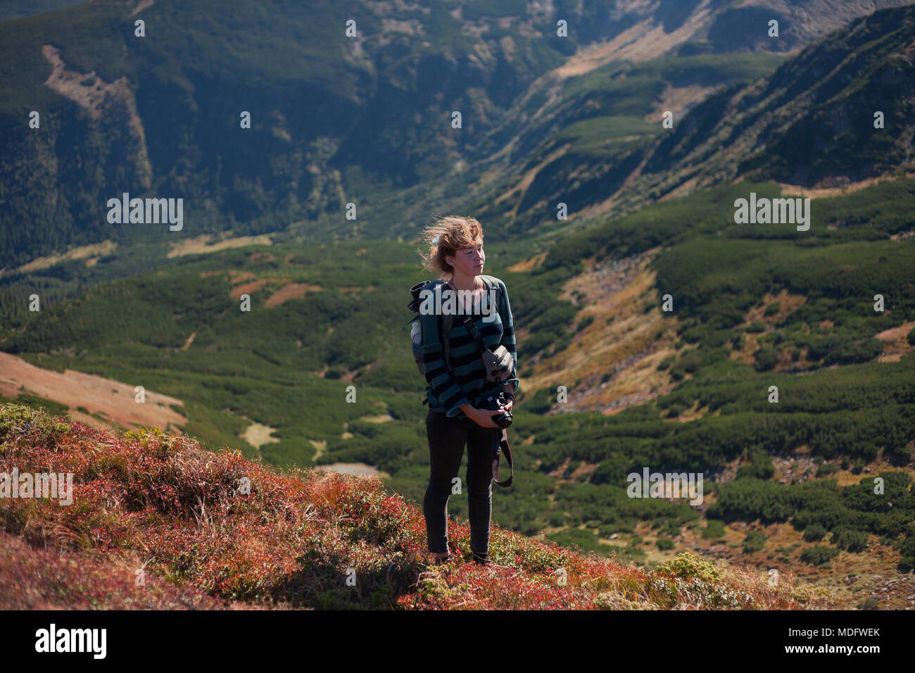 Woman standing on mountain slope looking at view, Ukraine Stock Photo