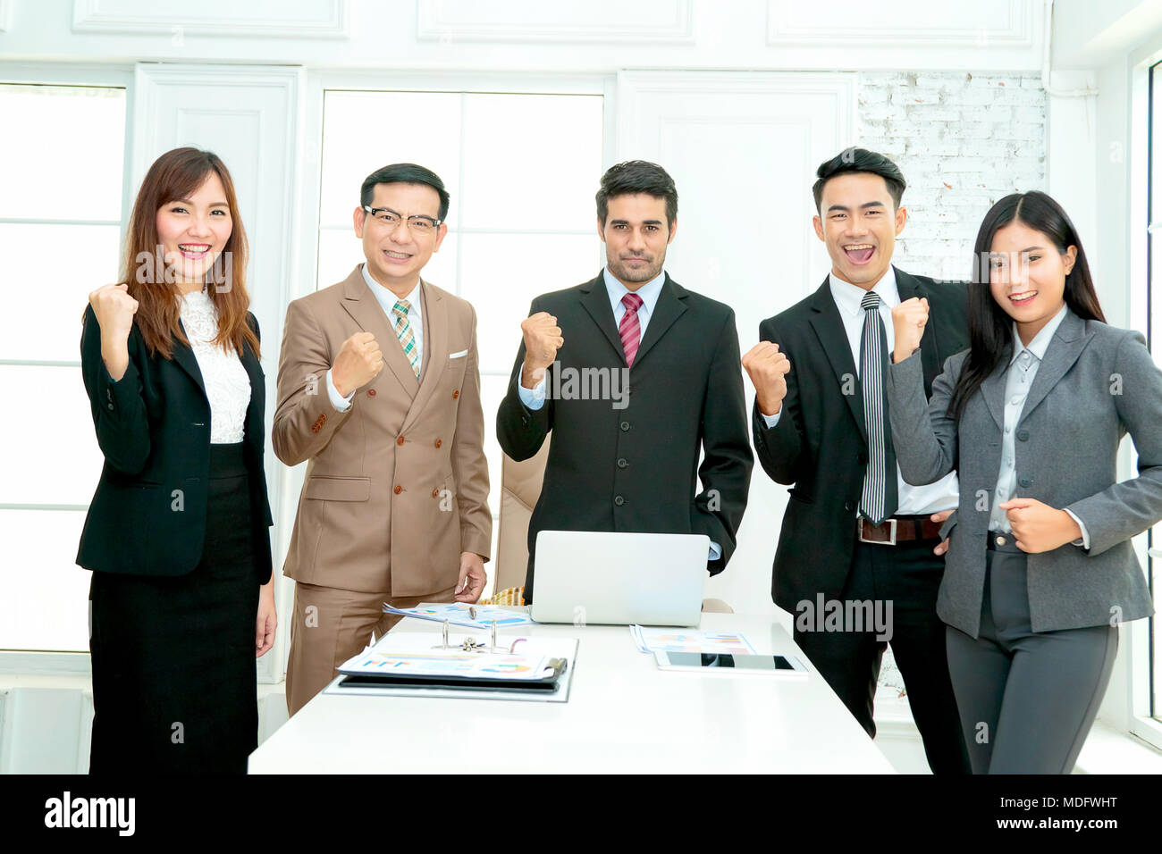 Successful business team celebrating with arms up Stock Photo - Alamy