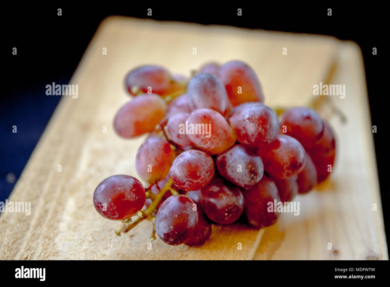 Bunch of grapes on a chopping board Stock Photo