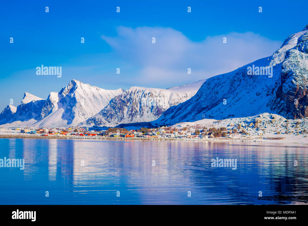 Outdoor view of buildings in the seaside with a huge mountain behind in ...