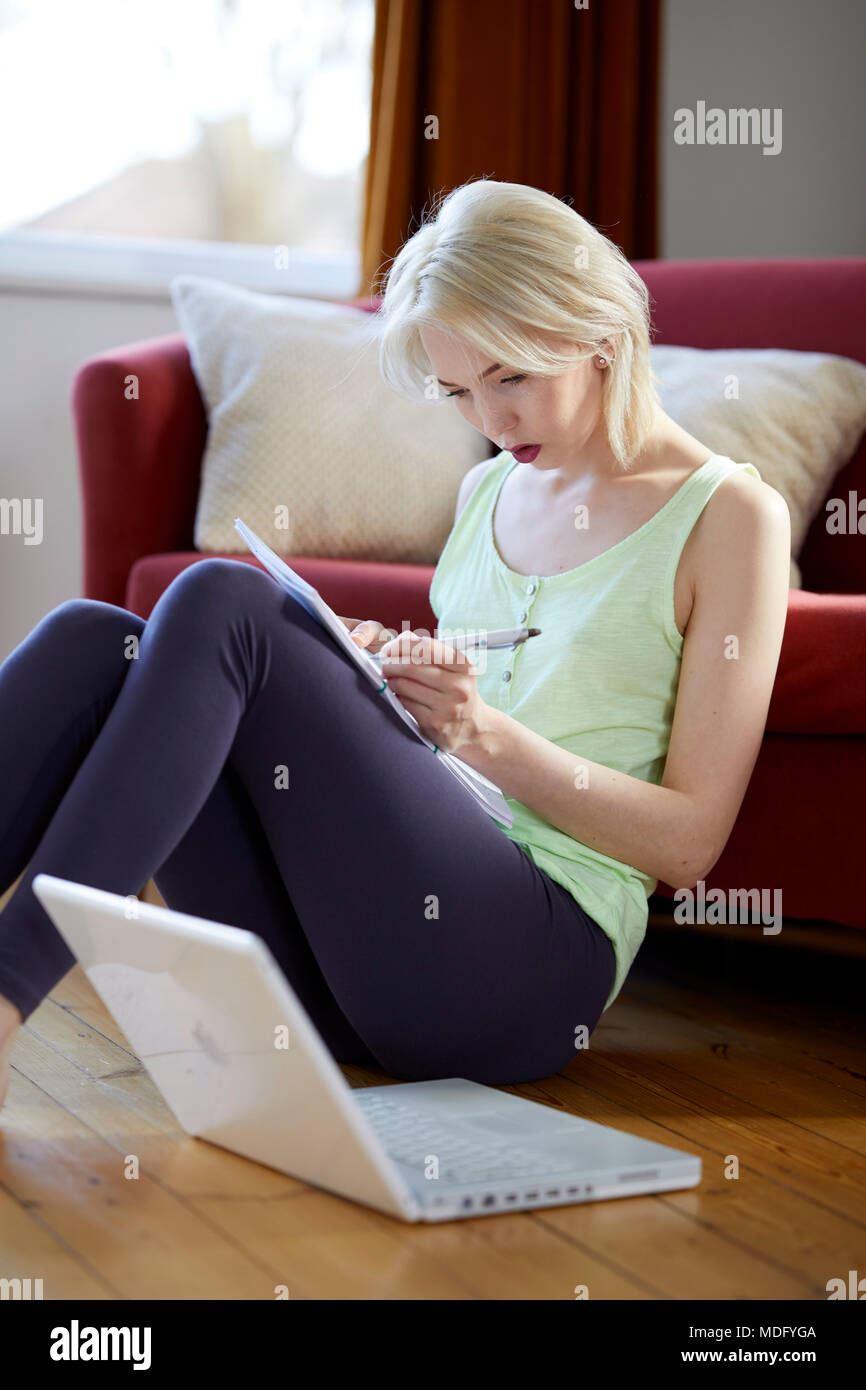 Woman sat at home using a laptop computer Stock Photo