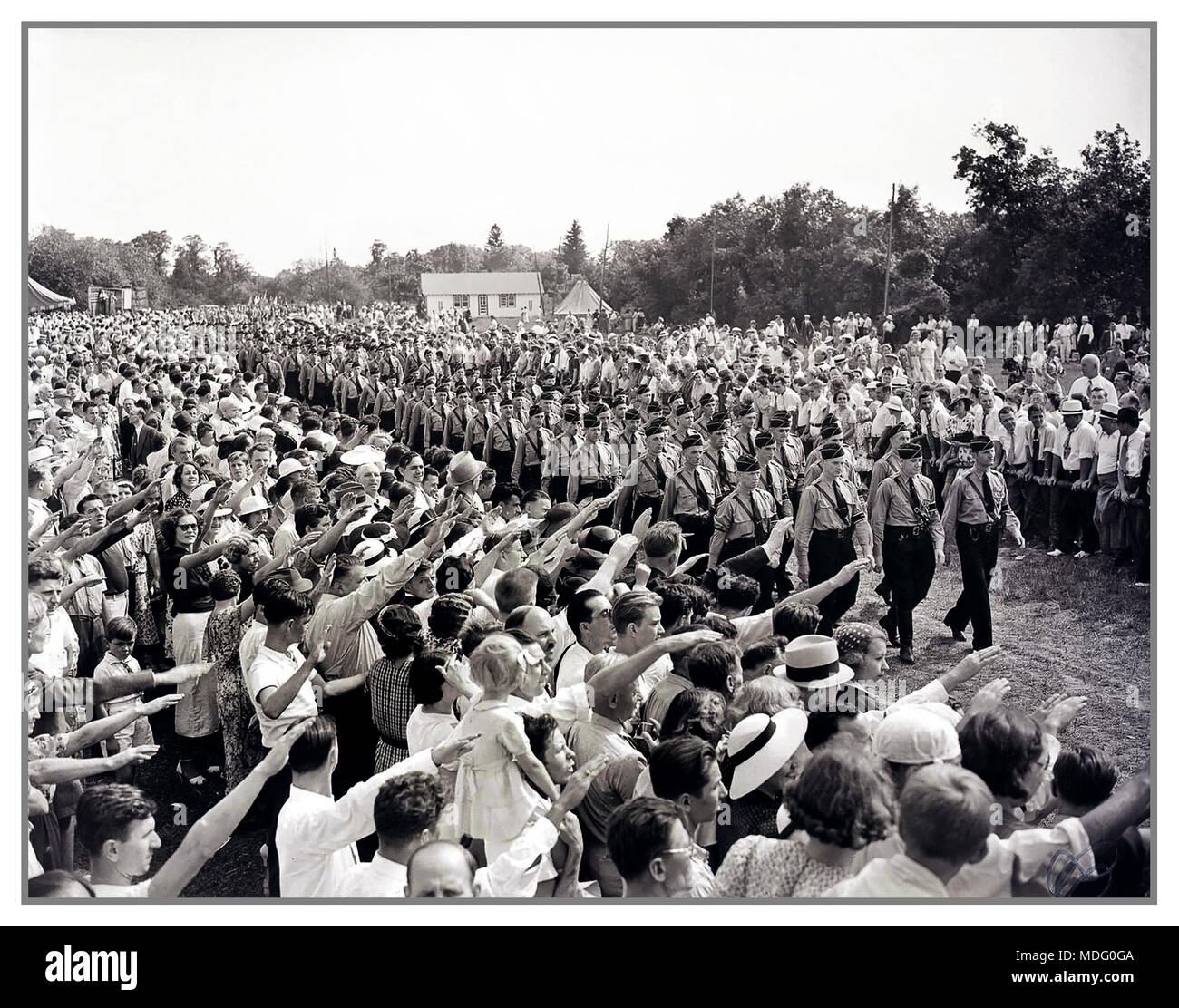 Vintage Historic Pre WW2 Image of German Americans extoling “German virtues,” giving the Nazi salute to young men marching in Nazi uniforms. The event was a German Day celebration promoted by the German American Bund Camp Sigfried  Long Island USA Stock Photo