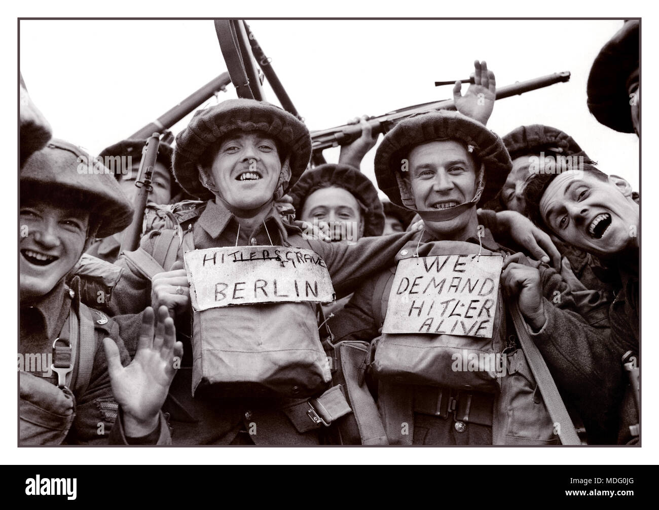 WW2 Dunkirk and the Retreat From France  26th May-4th June 1940 Cheerful British troops very happy to be in the UK after being evacuated from Dunkirk. Two  wearing labels with upbeat slogans..  'Hitler's Grave Berlin' and 'We demand Hitler Alive'. World War II Datebetween 1939 and 1945 Stock Photo