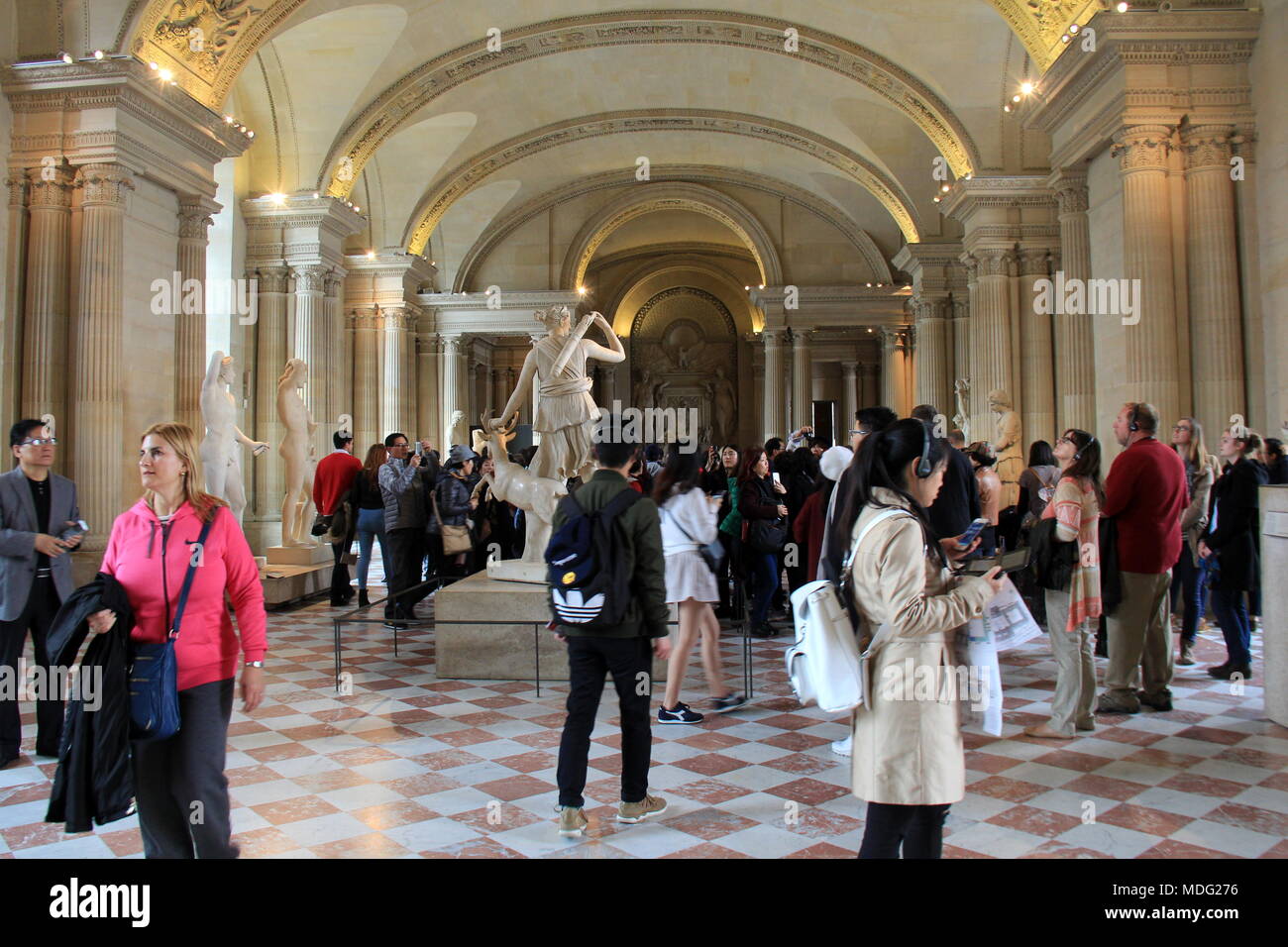 Visitors from all over the world walk through the halls and rooms of The Louvre, Paris, France. Stock Photo