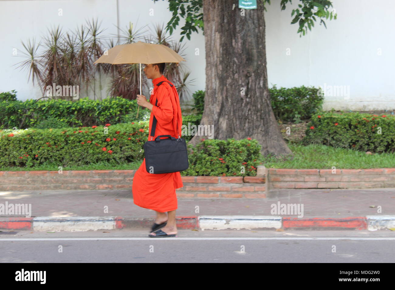 Monk walking on  Lan Xang Road near Wat Si Saket, Vientiane, Laos. 2015. Stock Photo