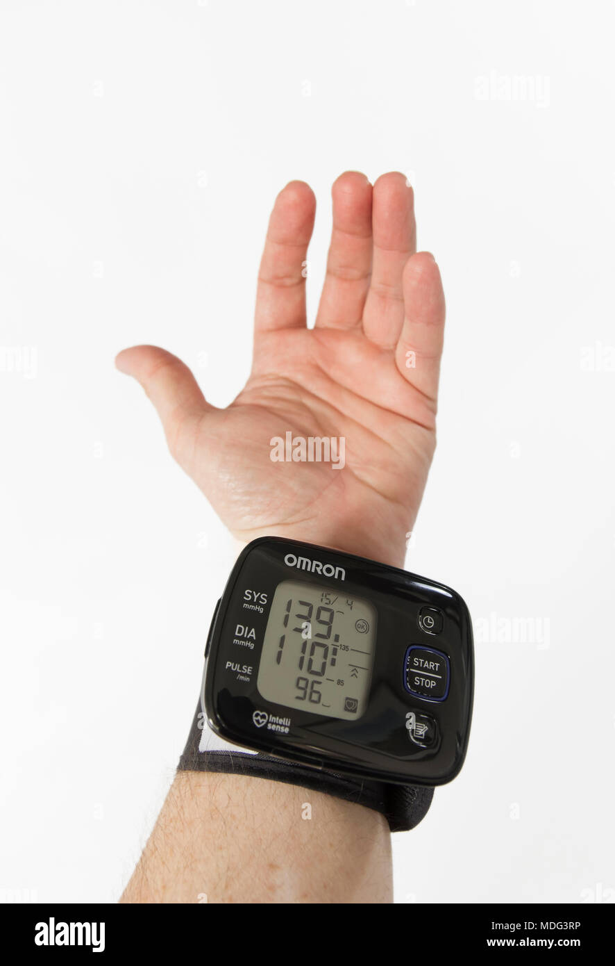 Taking blood pressure readings at home with a wrist monitor. a male
