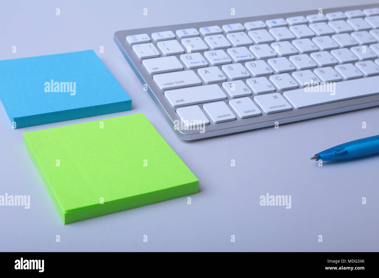 Office desk with keyboard and stikers, papers Stock Photo